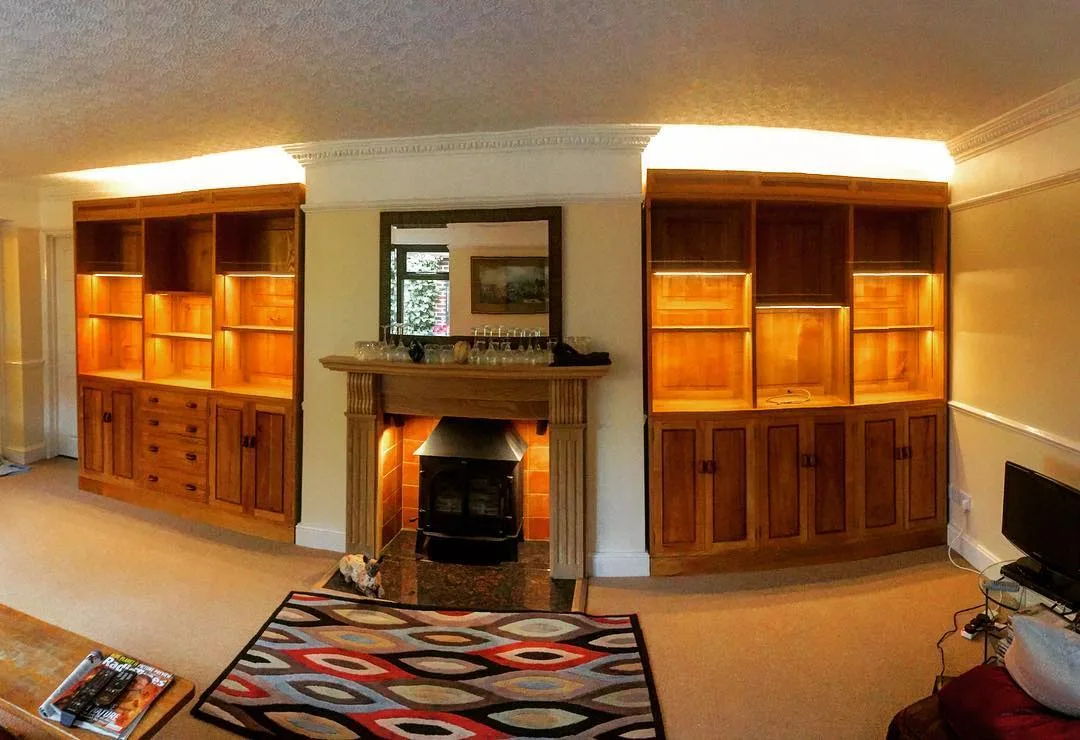 Fireplace alcove bookcases finished with hidden cove LED lighting above each shelf