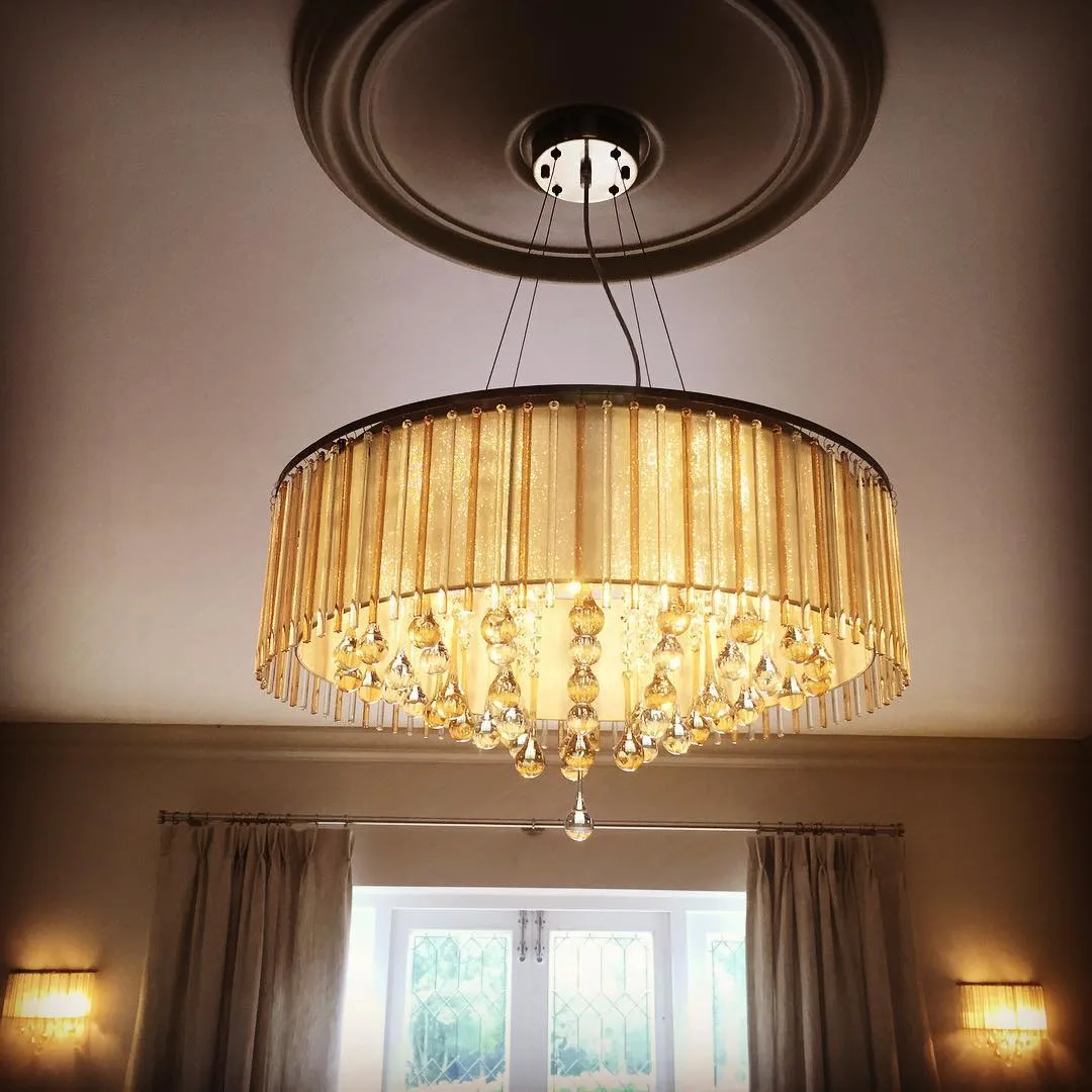 Ornate crystal-drop pendant chandelier lighting a period living room