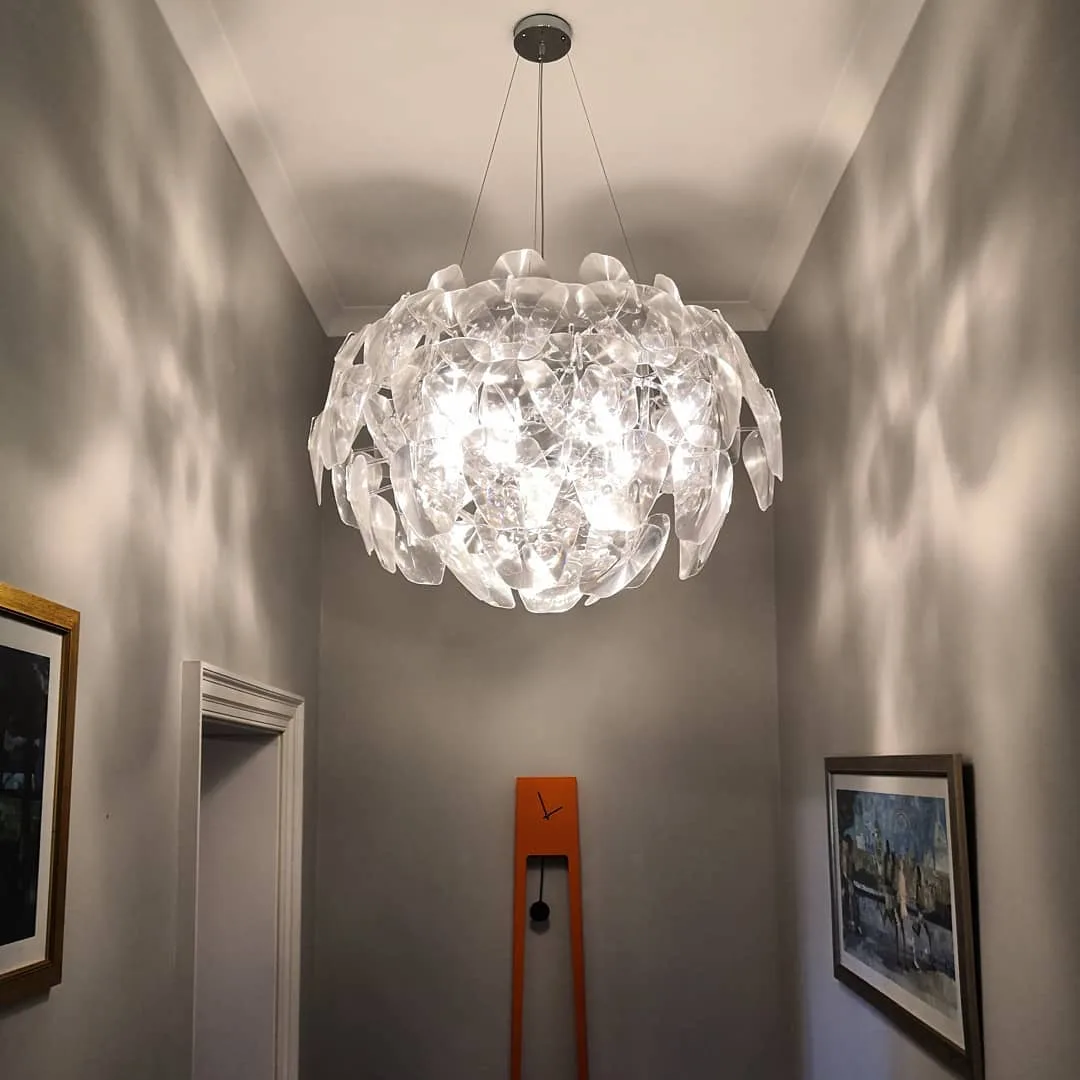 Modern glass-leaf pendant chandelier lighting a hallway