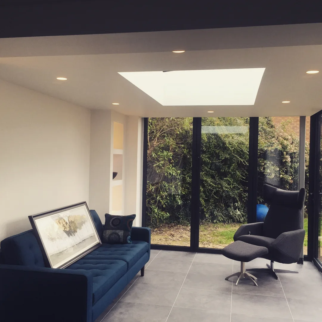 Finished garden-room extension lounge with a roof skylight and recessed downlights
