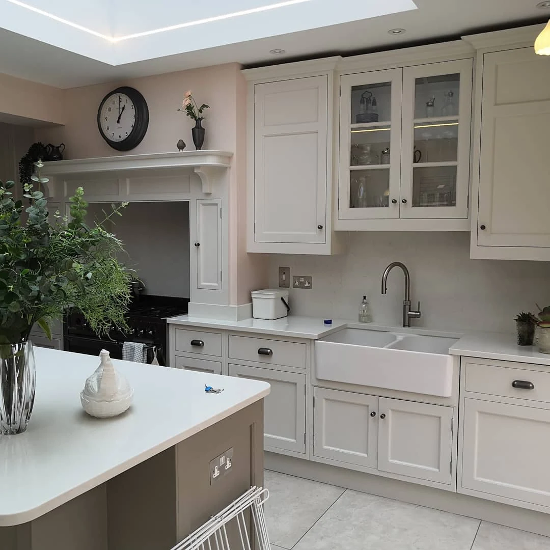 Finished cream shaker-style kitchen with pendant and glazed cabinet lighting